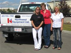 Staff standing in front of a Northwest Equipment Ltd pickup truck.
